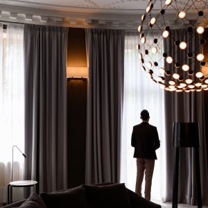 Faceless man looking at window indoors